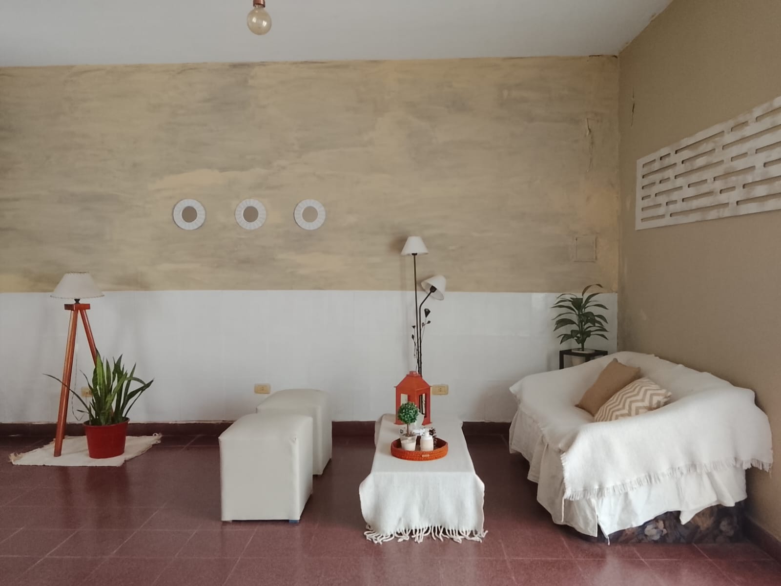 El consultorio: un sillón blanco, dos pufs y plantas